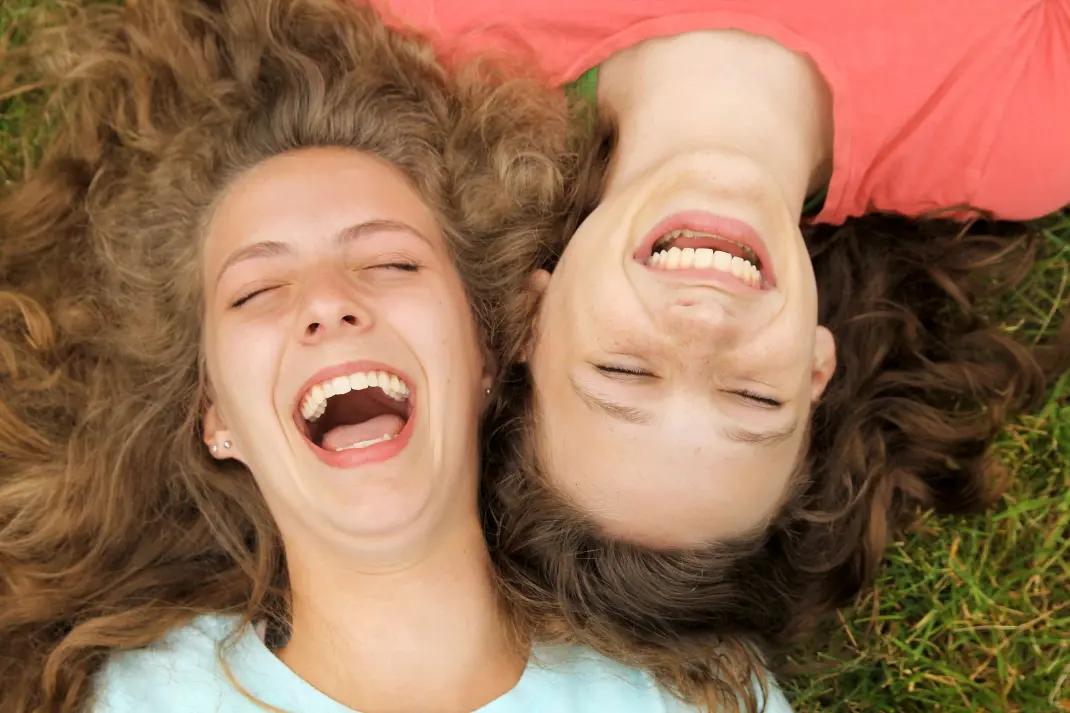 Lachende Frauen liegen auf dem Boden